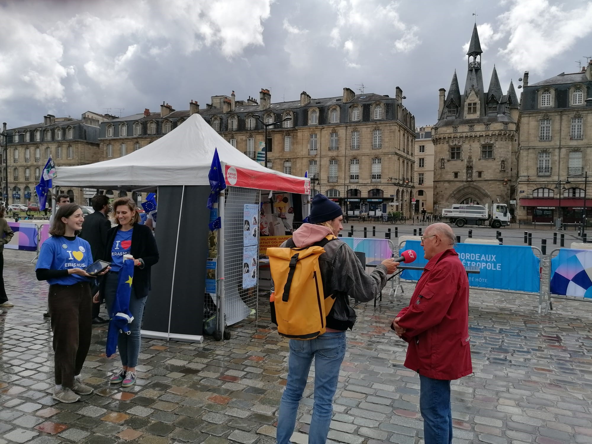 Un journaliste en train d'interviewer un monsieur au village de l'Europe, le long des quais à Bordeaux